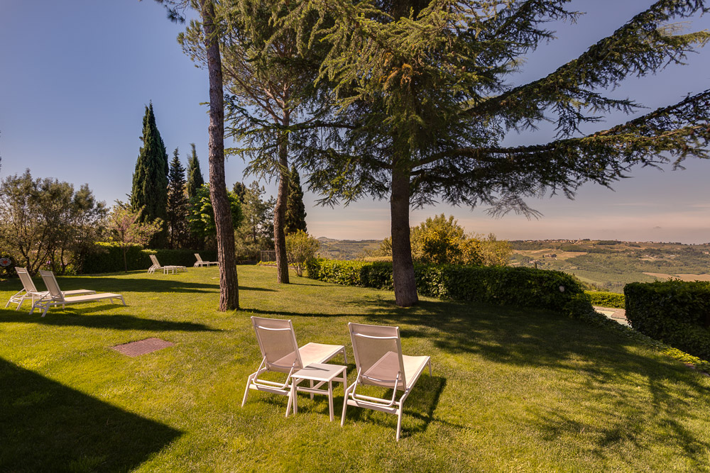 The luxurious garden of Villa I Barronci with hillside views over the Chianti
